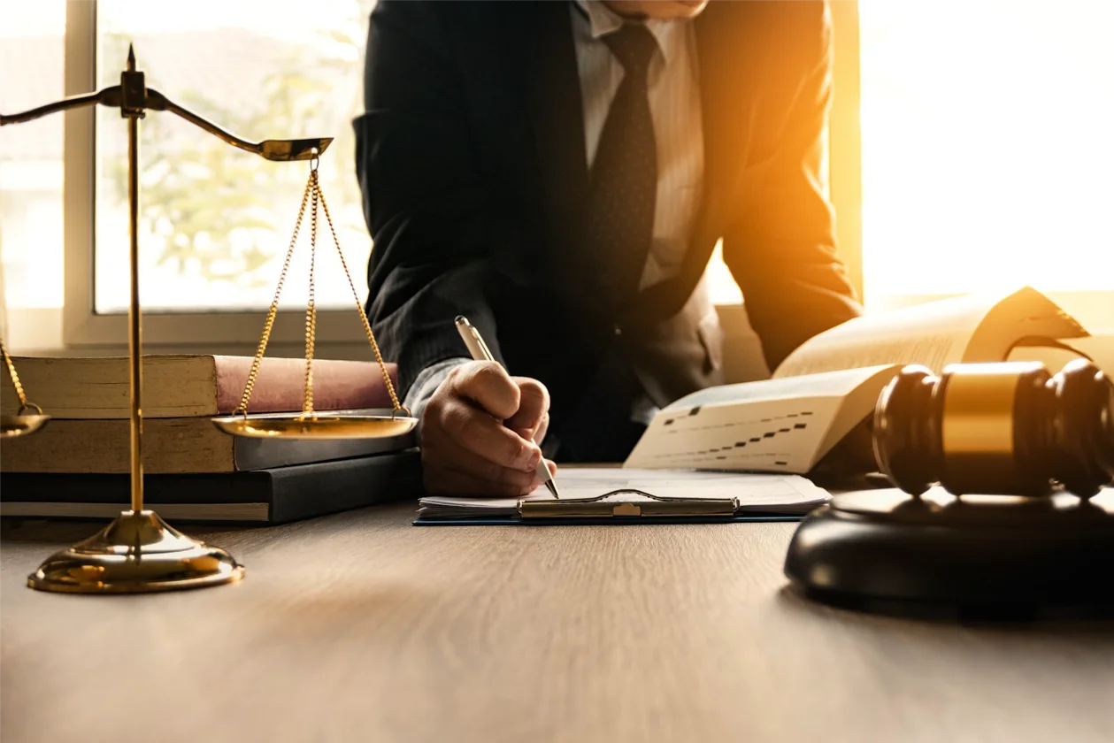 Estate attorney studying documents beside a balance scale and law books
